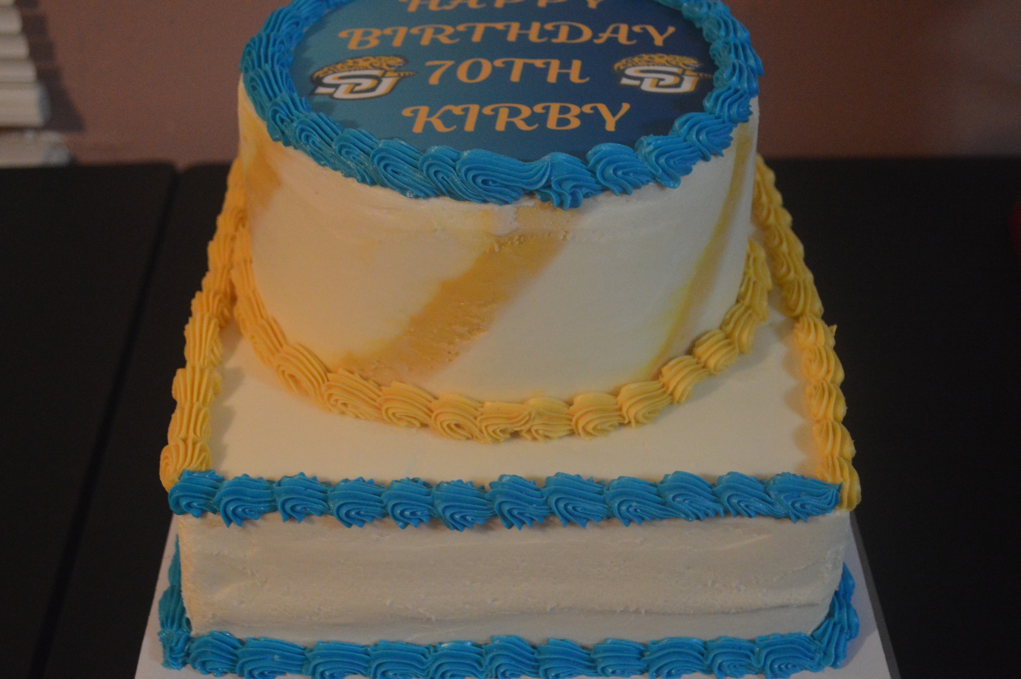 Blue, gold, and white tier cake with a birthday image on top