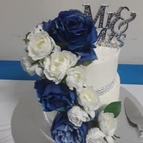 Two-tier wedding cake decorated with blue and white flowers